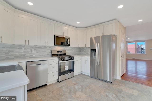 kitchen featuring white cabinetry, backsplash, and stainless steel appliances