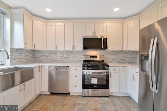 kitchen featuring appliances with stainless steel finishes, sink, decorative backsplash, and cream cabinetry