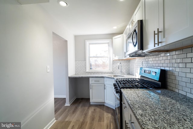 kitchen featuring sink, tasteful backsplash, light stone counters, appliances with stainless steel finishes, and white cabinets