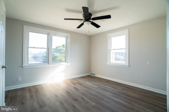 empty room with dark hardwood / wood-style flooring and ceiling fan