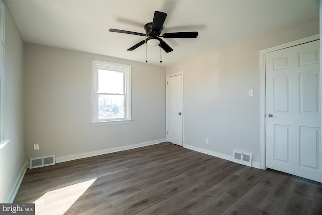 spare room with ceiling fan and dark hardwood / wood-style floors