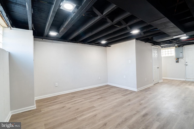 basement with wood-type flooring and electric panel