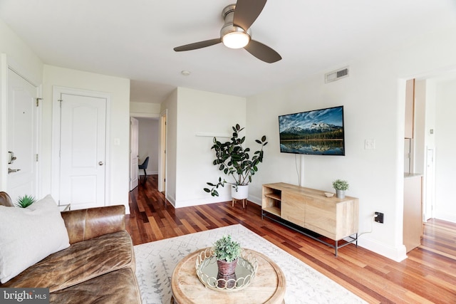 living room featuring hardwood / wood-style floors and ceiling fan