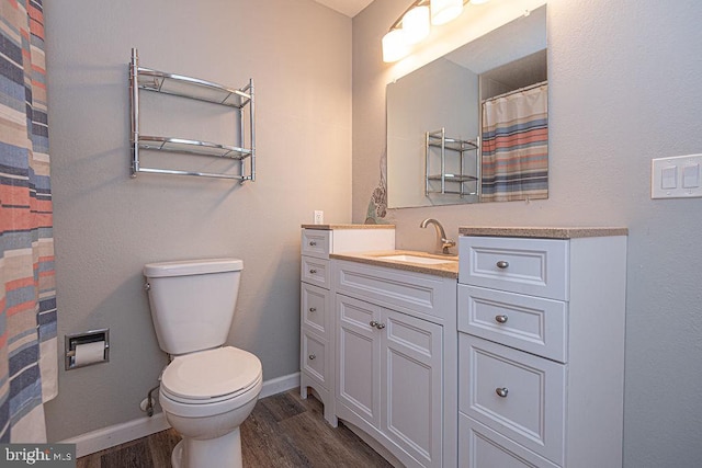 bathroom with hardwood / wood-style flooring, vanity, and toilet