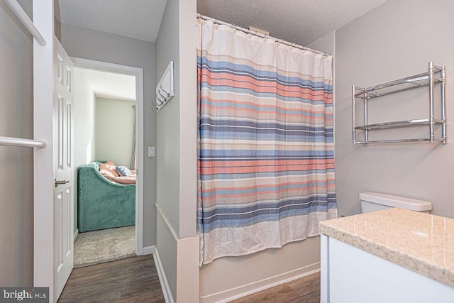 bathroom featuring hardwood / wood-style flooring, vanity, and a textured ceiling