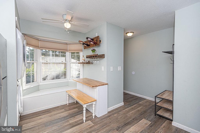 dining room with ceiling fan, dark hardwood / wood-style floors, and a textured ceiling