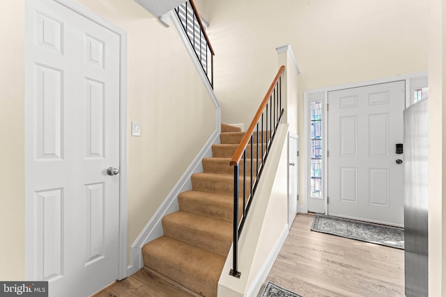 foyer with light hardwood / wood-style floors and a high ceiling