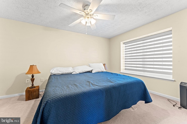 carpeted bedroom with ceiling fan and a textured ceiling