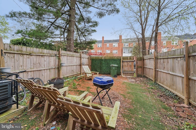 view of yard featuring a fenced backyard and a fire pit