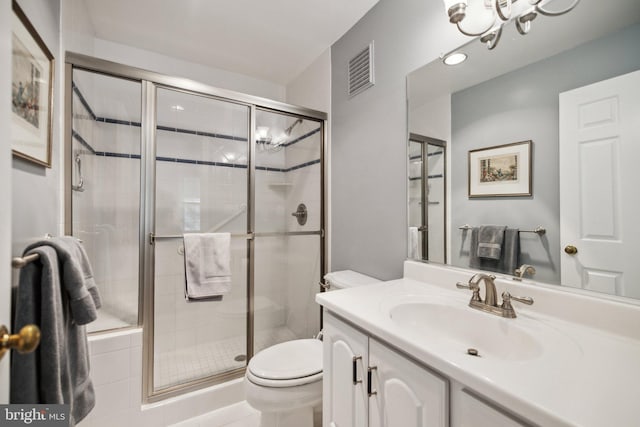 bathroom with vanity, a shower with door, and toilet