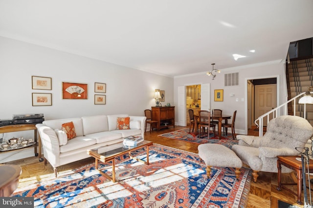 living room with ornamental molding, parquet flooring, and a notable chandelier