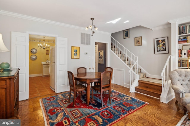 dining room with ornamental molding, parquet floors, and a chandelier