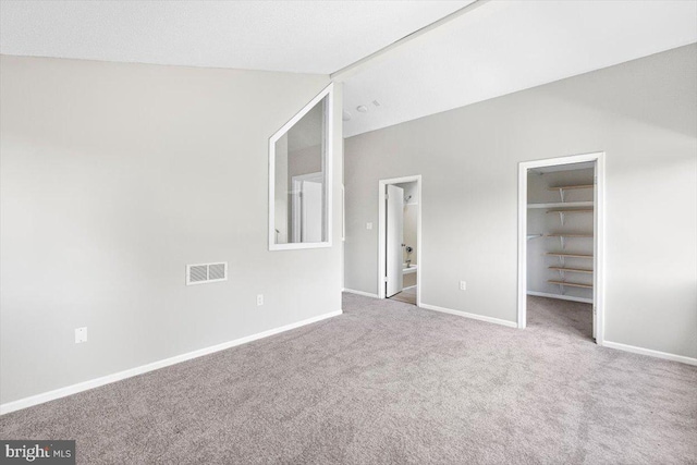 unfurnished bedroom with carpet floors, a walk in closet, and a closet