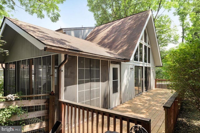 view of home's exterior with a wooden deck and a sunroom