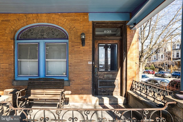 view of exterior entry featuring brick siding