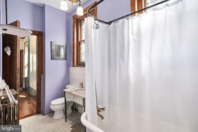 bathroom with shower / bath combo, a sink, and toilet