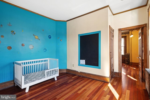 unfurnished bedroom featuring crown molding, baseboards, and wood finished floors