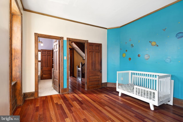 unfurnished bedroom featuring crown molding, dark wood finished floors, and baseboards