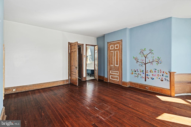 empty room featuring dark wood-style floors and baseboards