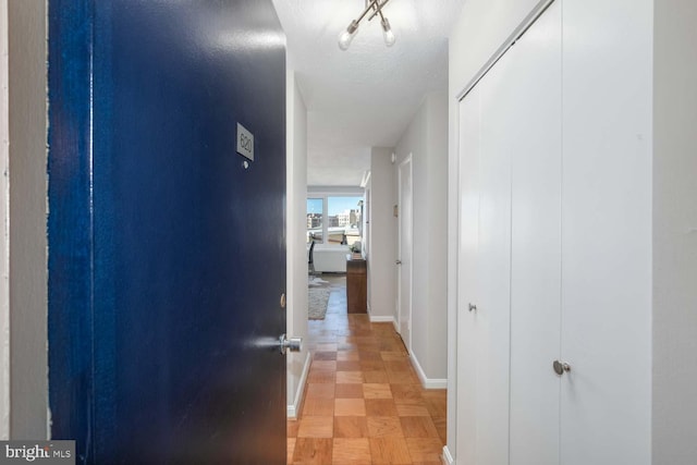 corridor featuring a textured ceiling and light parquet floors