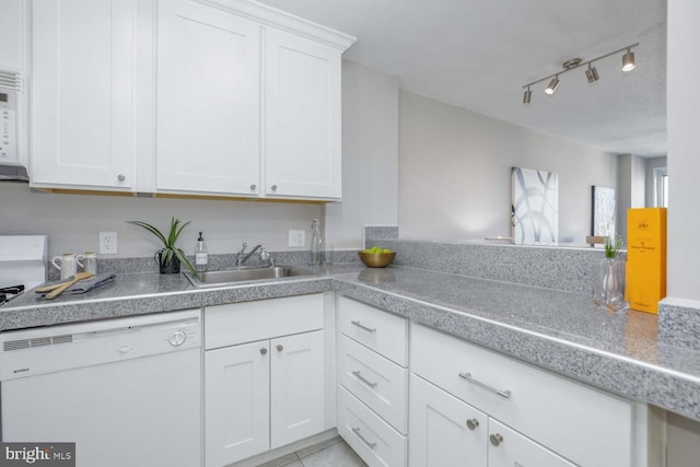 kitchen with sink, light tile patterned floors, white cabinets, and white dishwasher