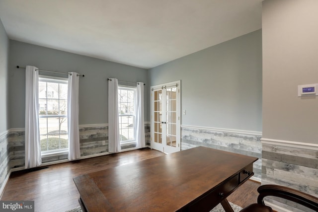 unfurnished office with dark wood-style floors, french doors, and wainscoting