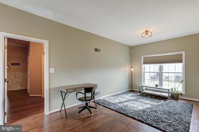 office space featuring dark wood-type flooring, visible vents, and baseboards