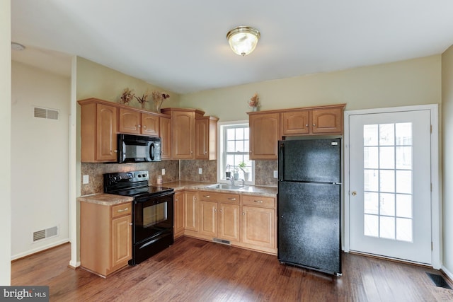 kitchen featuring black appliances, backsplash, dark wood finished floors, and visible vents