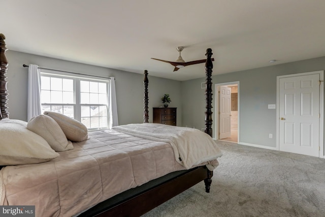 carpeted bedroom with ensuite bath and baseboards