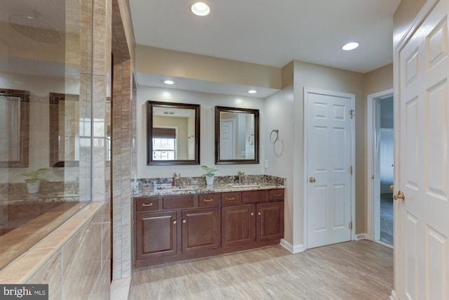 bathroom featuring recessed lighting, a sink, and double vanity