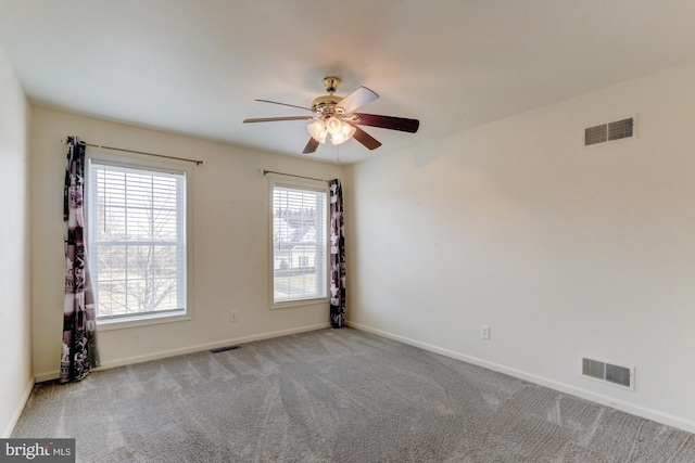 empty room featuring light carpet, baseboards, and visible vents