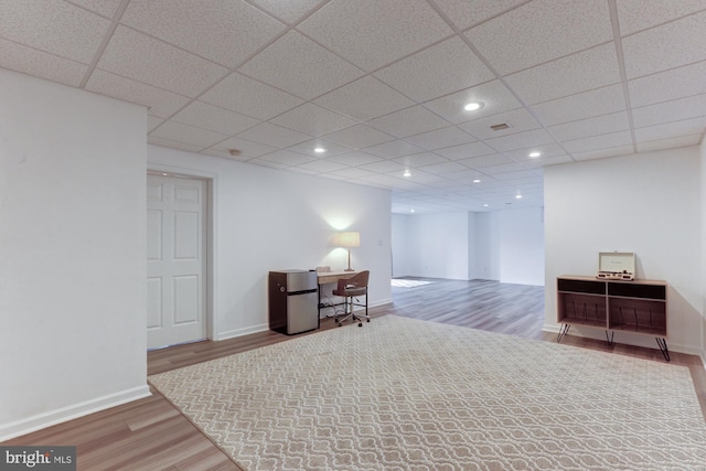 interior space with baseboards, wood finished floors, a paneled ceiling, and recessed lighting