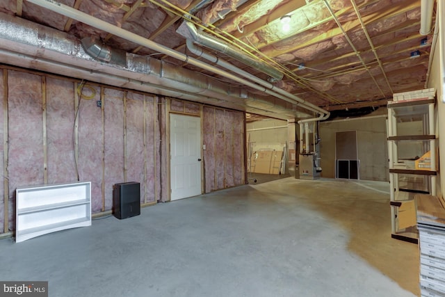 unfinished basement featuring heating unit