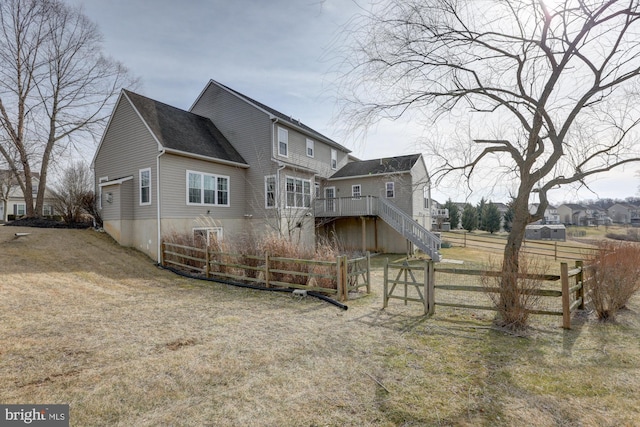 rear view of house with stairs, a deck, and fence