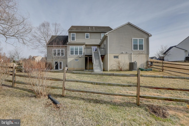 back of property with a deck, cooling unit, fence, stairway, and a lawn