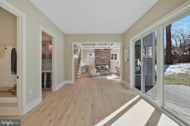 sunroom / solarium featuring beamed ceiling and a fireplace