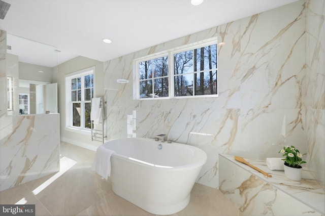 bathroom with a bath and a wealth of natural light