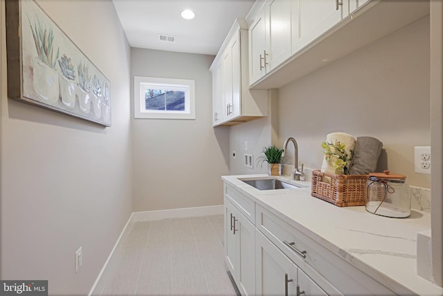 clothes washing area featuring cabinets, hookup for an electric dryer, sink, and washer hookup