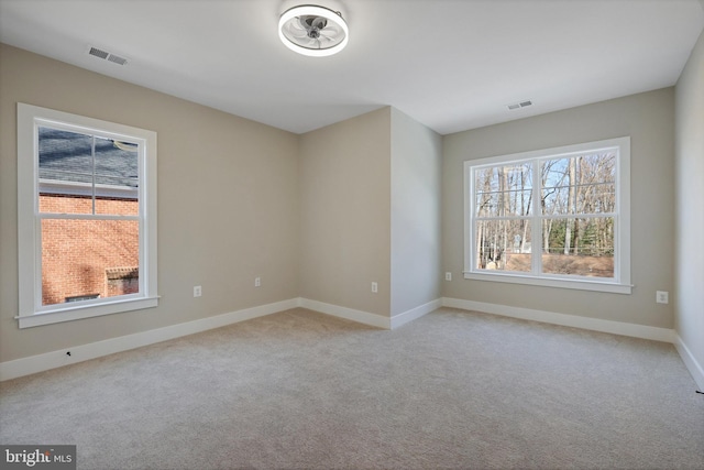 unfurnished room with light colored carpet and a healthy amount of sunlight