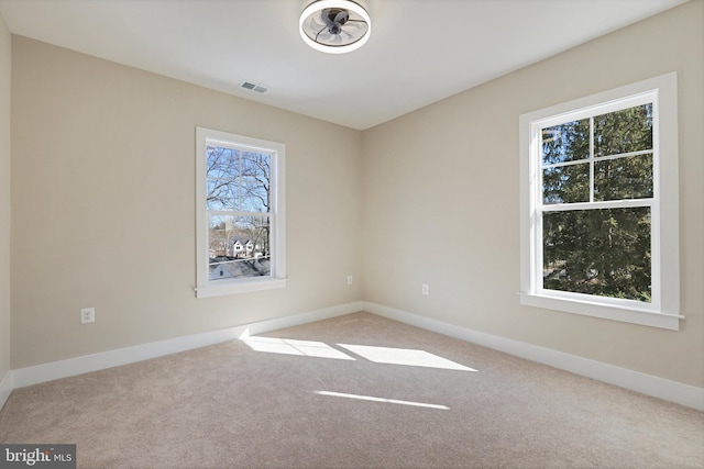 carpeted spare room featuring plenty of natural light