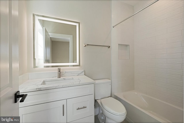 full bathroom with tiled shower / bath, vanity, and toilet