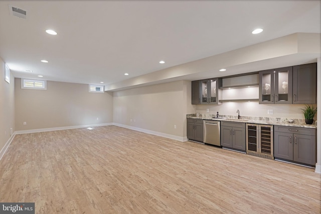 bar with sink, light hardwood / wood-style flooring, dishwasher, wine cooler, and light stone counters