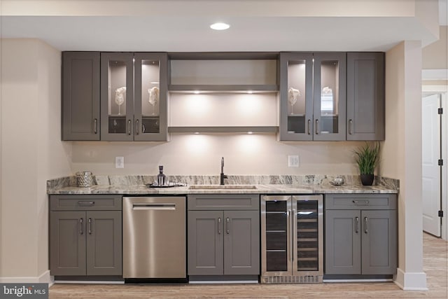 kitchen with gray cabinets, light stone countertops, stainless steel dishwasher, and beverage cooler