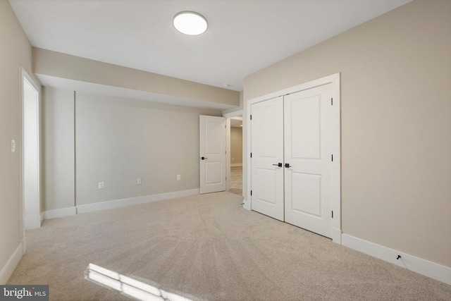 unfurnished bedroom featuring light carpet and a closet