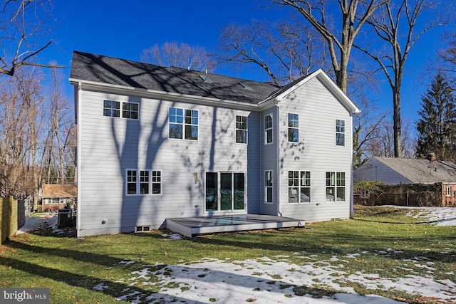 snow covered rear of property featuring a yard and a deck