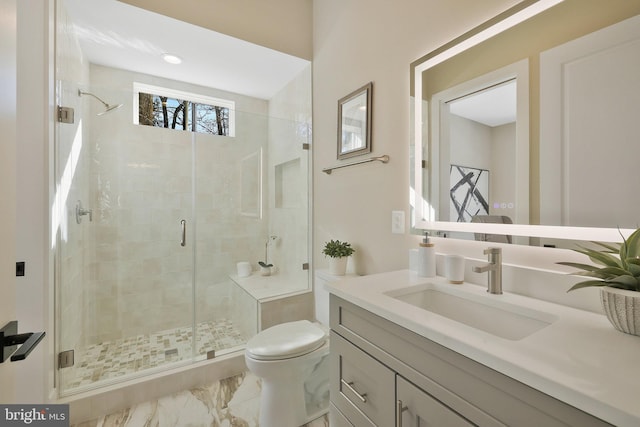 bathroom featuring vanity, toilet, and an enclosed shower