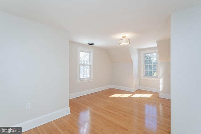 additional living space with lofted ceiling and light hardwood / wood-style flooring