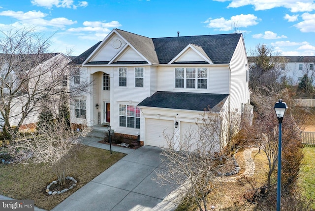 traditional-style home with driveway, roof with shingles, and an attached garage