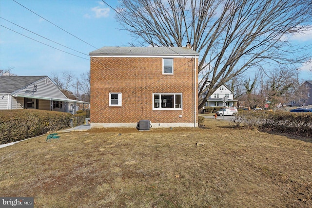 rear view of house with a yard and central air condition unit