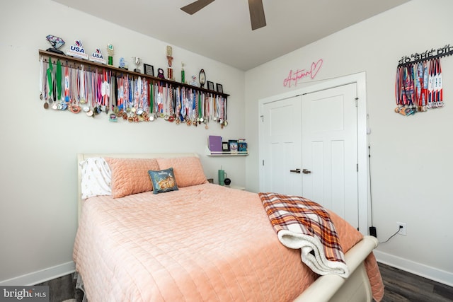 bedroom with dark hardwood / wood-style flooring, ceiling fan, and a closet